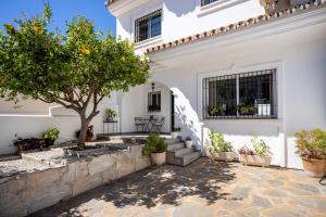 福恩吉罗拉Casa Los Limones的庭院里一棵树的白色房子