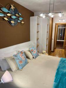 里瓦德塞利亚Apartamentos El Escudo Centro的卧室配有带蓝色枕头的大型白色床