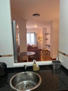 里瓦德塞利亚Apartamentos El Escudo Centro的一间带水槽的浴室和一间客厅