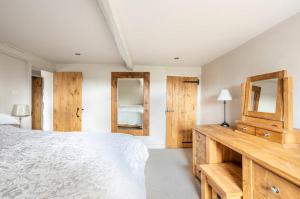 塞特尔Primrose Cottage with Log Burner (Dog Friendly)的卧室配有白色的床和木制橱柜。
