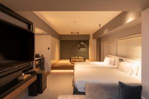 大阪Hotel Keihan Namba Grande的酒店客房设有两张床和一台平面电视。