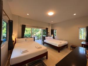 春蓬Naisang Hostel的酒店客房设有两张床和一个阳台。
