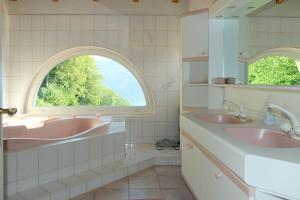 法伦湖Villa Nora的一间带两个盥洗盆和拱形窗户的浴室