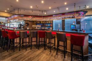 海尔布隆卡斯特尔最佳西方酒店的餐厅内带红色酒吧凳的酒吧