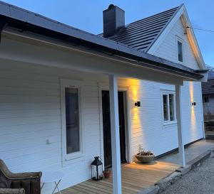 艾菲约德Cozy house in Eidfjord的白色房子的门廊,设有木甲板