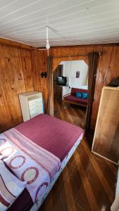 拉科罗尼亚Maridalba的卧室配有一张床铺,位于带木墙的房间内