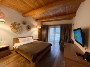 YasnogorodkaEden Resort的一间卧室配有一张床和一台平面电视