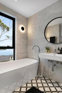 悉尼Luxury Waterside Home Sanctuary的带浴缸、水槽和镜子的浴室