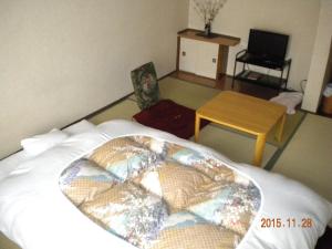 旭川米玛特苏索旅馆的一间卧室配有一张大床、一张桌子和一张桌子