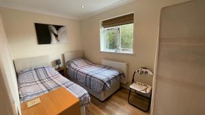 福丁布里奇Swallows Retreat的小房间设有两张床和窗户