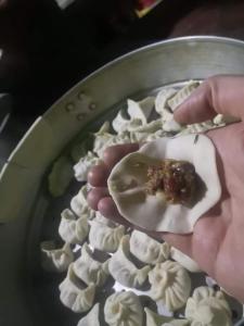 图利凯尔Namaste Home Stay的把食物放在一盘食物中的人