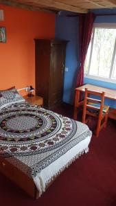 图利凯尔Namaste Home Stay的一间卧室配有一张床、一张桌子和一个窗户。