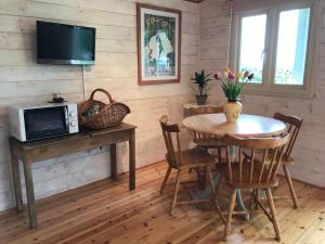 Weston LongvilleTranquil Log Cabin - Beautiful Rural Sunset Views的一间带桌子和电视的用餐室