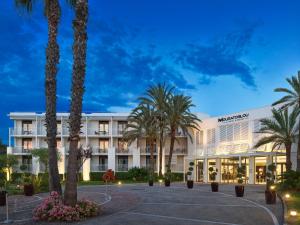比奥Mouratoglou Hotel & Resort的前面有棕榈树的酒店