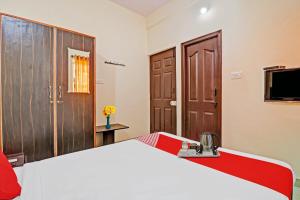 班加罗尔Super OYO Mn Residency Near Ragigudda Sri Prasanna Anjaneyaswamy Temple的一间卧室配有一张大床和电视