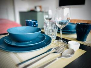 斯容代克Flamingo Studio's Zeeland的一张带蓝色盘子的桌子和一杯葡萄酒
