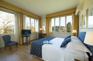 佛罗伦萨公园宫殿酒店的一间卧室设有一张床和两个窗户。