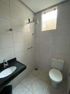 迪维诺波利斯Pousada Elita的白色的浴室设有卫生间和水槽。