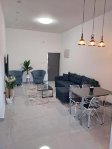 提比里亚Puy Rambam's apartment Tiberias的客厅配有蓝色的沙发和桌子
