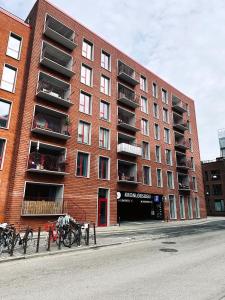哥本哈根ApartmentInCopenhagen Apartment 1463的一座红砖建筑,前面停放着自行车