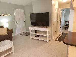 威尼斯Venice Gardens, 2-Br Pet Friendly Home - Indra的一间客厅,客厅内配有一台平面电视,位于白色娱乐中心