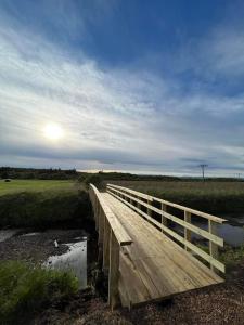 EiðarEiðar - Hostel的天上阳光的河上的木桥
