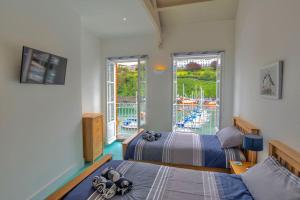 伊尔弗勒科姆Ultimate Harbourside的一间卧室设有两张床,享有游泳池的景色