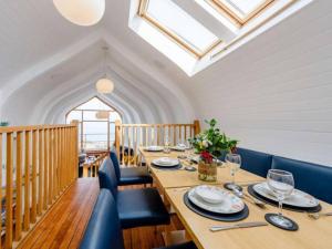 伊尔弗勒科姆Ultimate Harbourside的一间带长桌和蓝色椅子的用餐室
