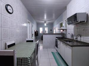 伯迪亚哥Casa individual aconchegante - Rio da praia - Bertioga的厨房配有桌子和水槽