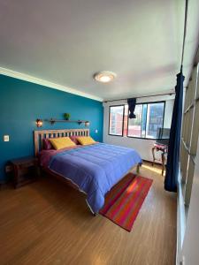 拉巴斯The Rooftop Bolivia的一间卧室配有一张带蓝色墙壁的大床