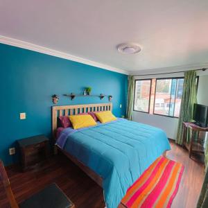 拉巴斯The Rooftop Bolivia的一间卧室配有一张蓝色墙壁的床
