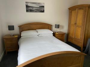波特帕特里克布林克伯尼旅馆的一间卧室配有一张带2个床头柜的大型木床