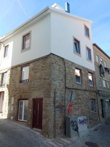 科维良Ritta´s House - Covilhã的街上有红色门的石头建筑