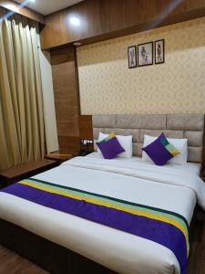 古尔冈Nearmi Hotels Banquets Medanta IKEA Sector 47 - Gurugram的一间卧室配有一张带紫色枕头的大床