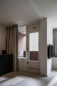 多德雷赫特Cloud Nine - romantic & design app in city center!的一个空房间,有门和窗户