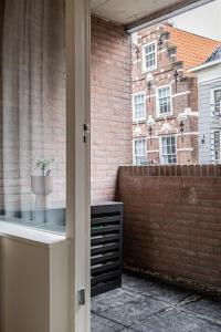 多德雷赫特Cloud Nine - romantic & design app in city center!的砖砌建筑的窗户景,有盆栽植物