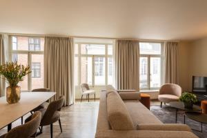 布鲁日Dukes' Apartments Grand Place的带沙发、椅子和窗户的客厅