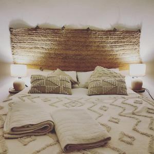 阿尔姆尼卡Esencia Lodge - luxurious off-grid cabin retreat的一张带毯子的床和两盏灯