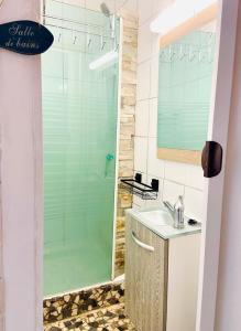 勒克罗图瓦gite le petit marin的一间带玻璃淋浴和水槽的浴室
