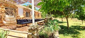 阿尔姆尼卡Esencia Lodge - luxurious off-grid cabin retreat的一座配有黑色沙发的房屋的庭院