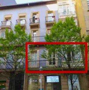 圣塞瓦斯蒂安NUEVO Apartamento en el centro de Donosti的前面有树木的建筑的红色图画