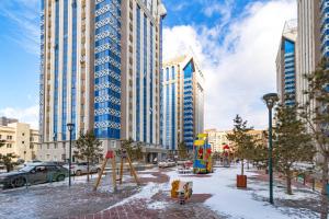 阿斯塔纳Жк Millennium Park,на Главной площади страны.的一座高楼城市的游乐场