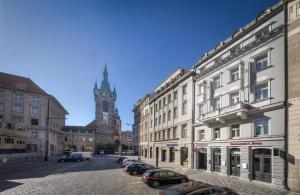 布拉格Hotel Essence的一条拥有建筑和钟楼城市街道