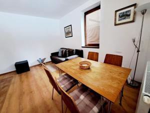 高塔特拉山Apartmán Severanka的客厅配有木桌和椅子