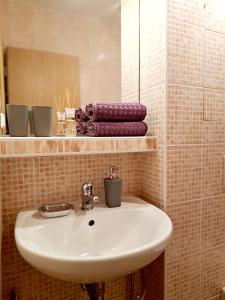高塔特拉山Apartmán Severanka的浴室配有盥洗盆、镜子和毛巾