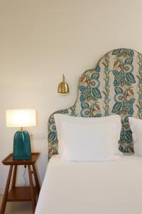 阿尔热祖尔Praia do Canal Nature Retreat的一间卧室配有一张床和一张桌子上的台灯