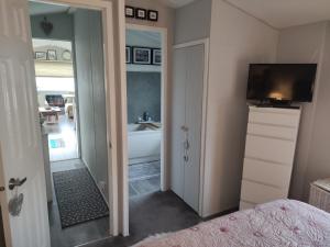 塞顿港"Dew Drop Inn"的一间卧室设有带浴缸的浴室和电视。