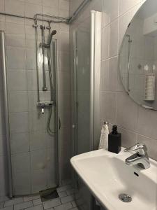 卡琳贡Käringöns Vandrarhem的带淋浴、盥洗盆和镜子的浴室