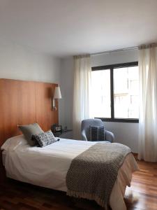 潘普洛纳Micampus Pamplona的卧室配有床、椅子和窗户。