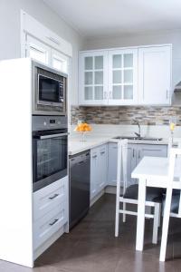 奥萨德蒙铁尔Casa Rural Los Eneares的厨房配有白色橱柜、桌子和微波炉